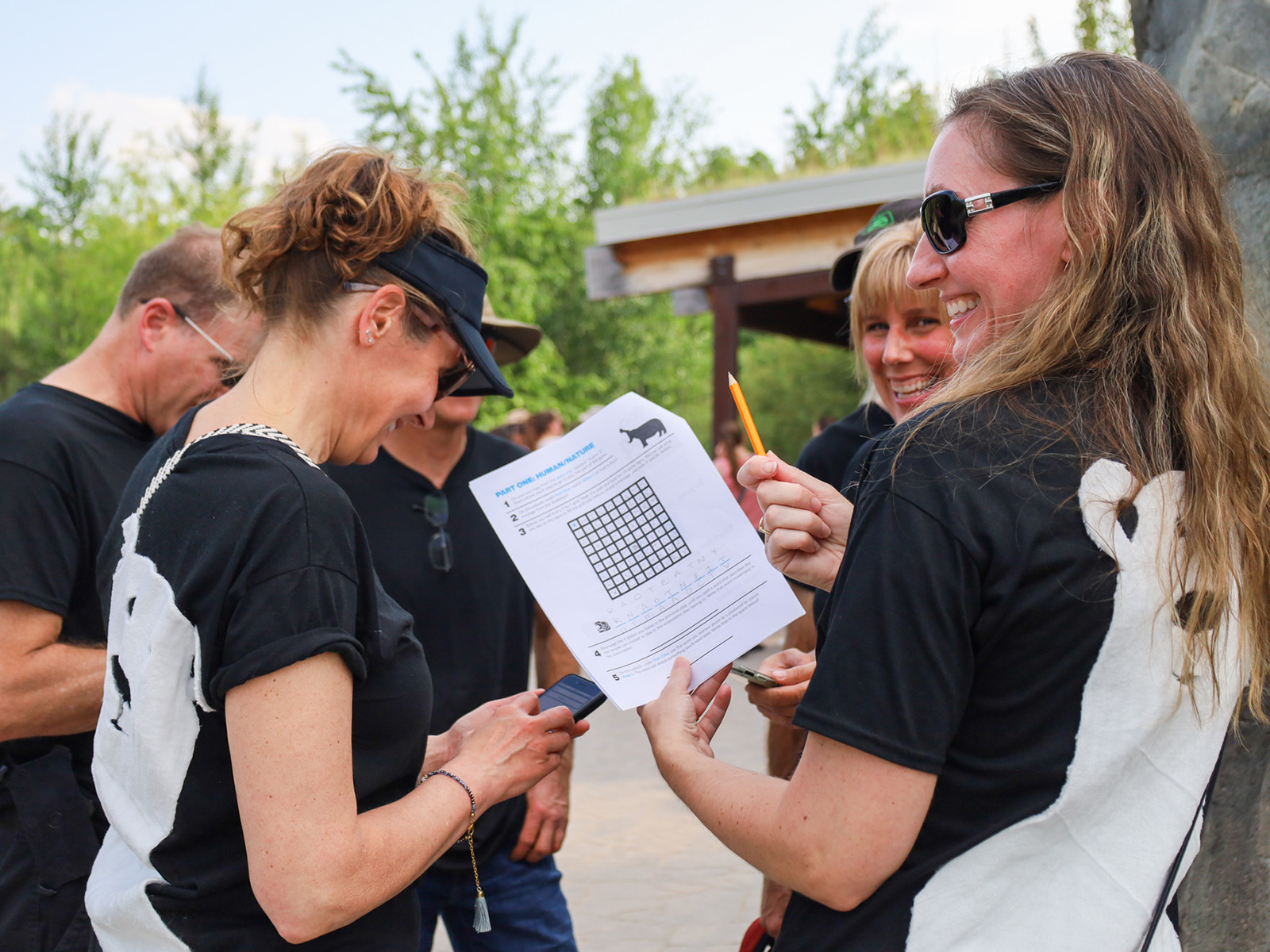 A group of adults in black shirts look a game worksheets 