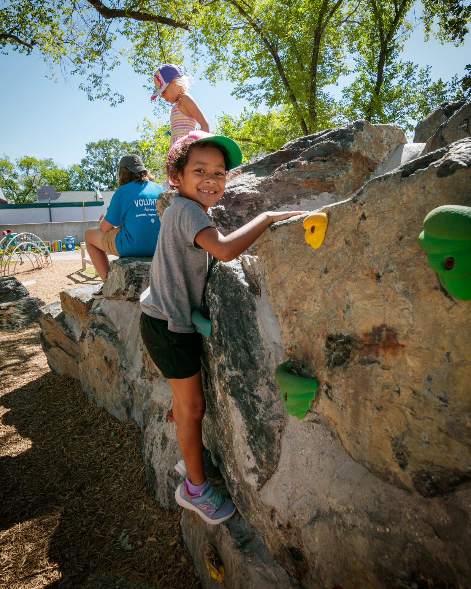 young boy climbs a climbing wall at Aunt Sally's Farm