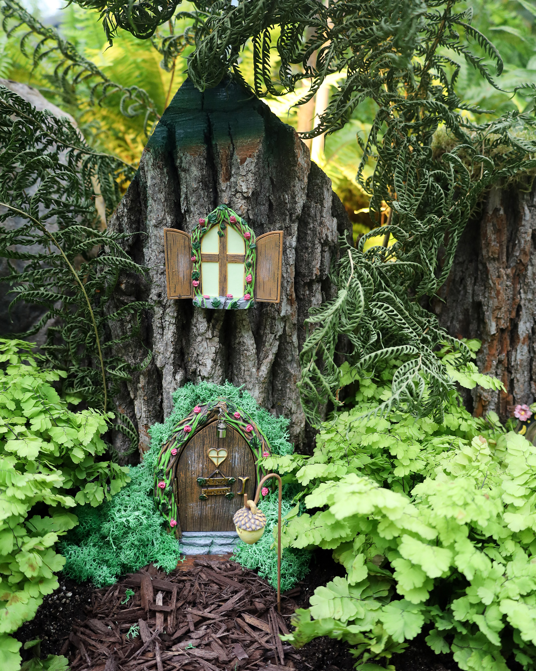 small fairy house nestled in between greenery